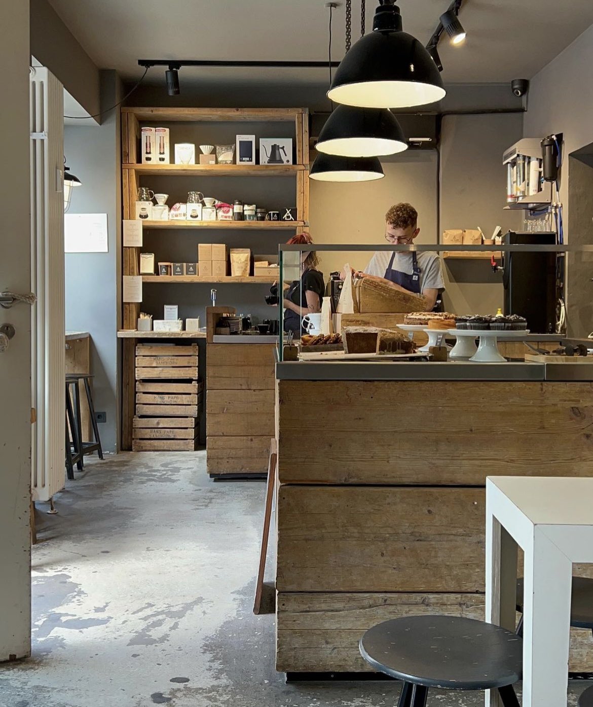 Cafe interior in Mitte, barista focus on a task behind the counter