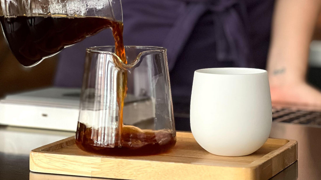 V60 dripper and server filled with tasty coffee, with commandante grinder in the background