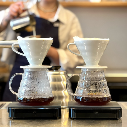 2 v60 coffee filter brewing, barista making a cappuccino on the back