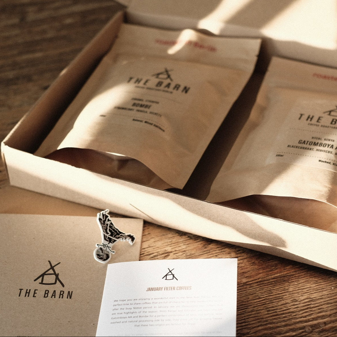 ROASTERS CHOICE SUBSCRIPTION coffee packaging with variety of beans and information card on wood table.