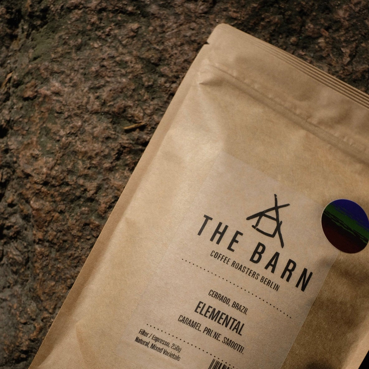 One bag of 'Elemental' coffee beans from 'The Barn', against a background of natural stone. 