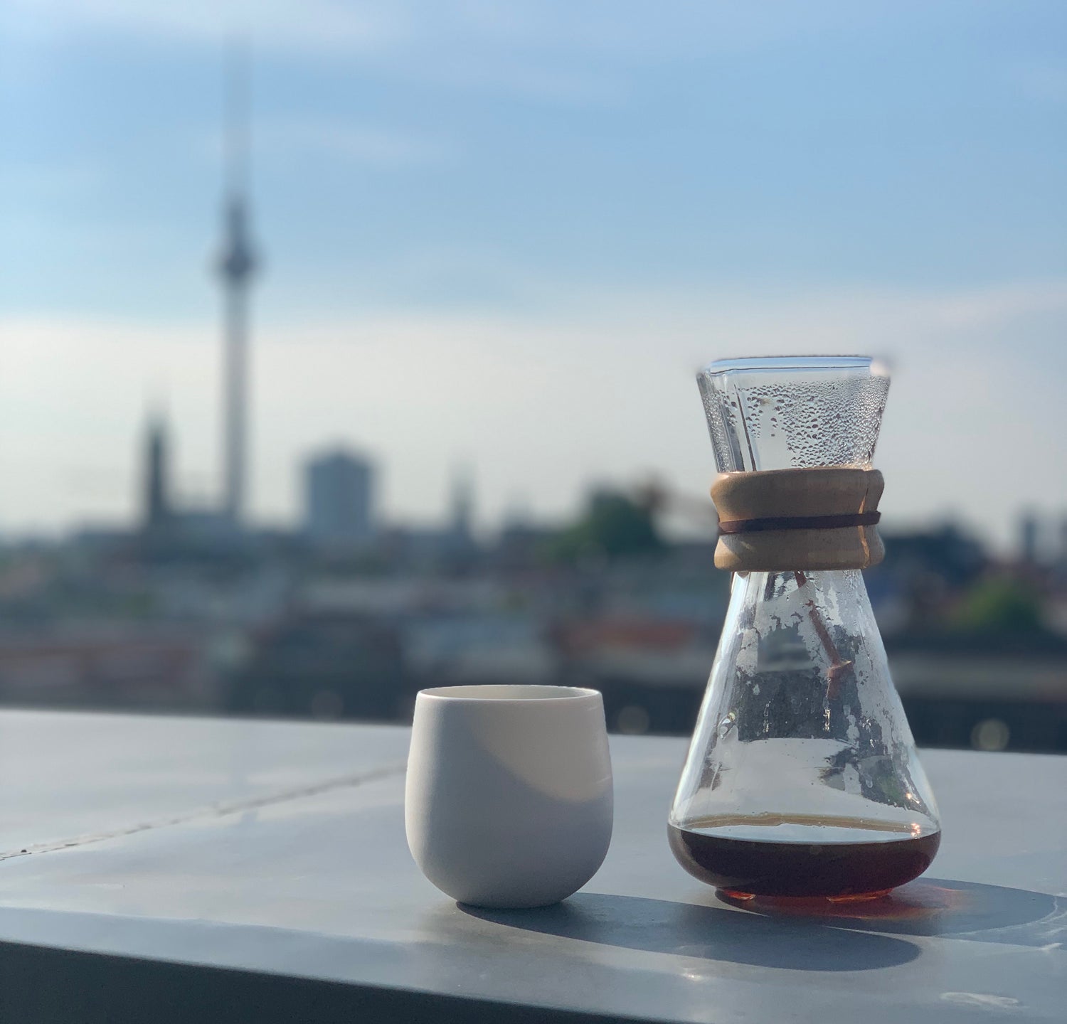 Chemex next to a cup with Berlin skyline on the background