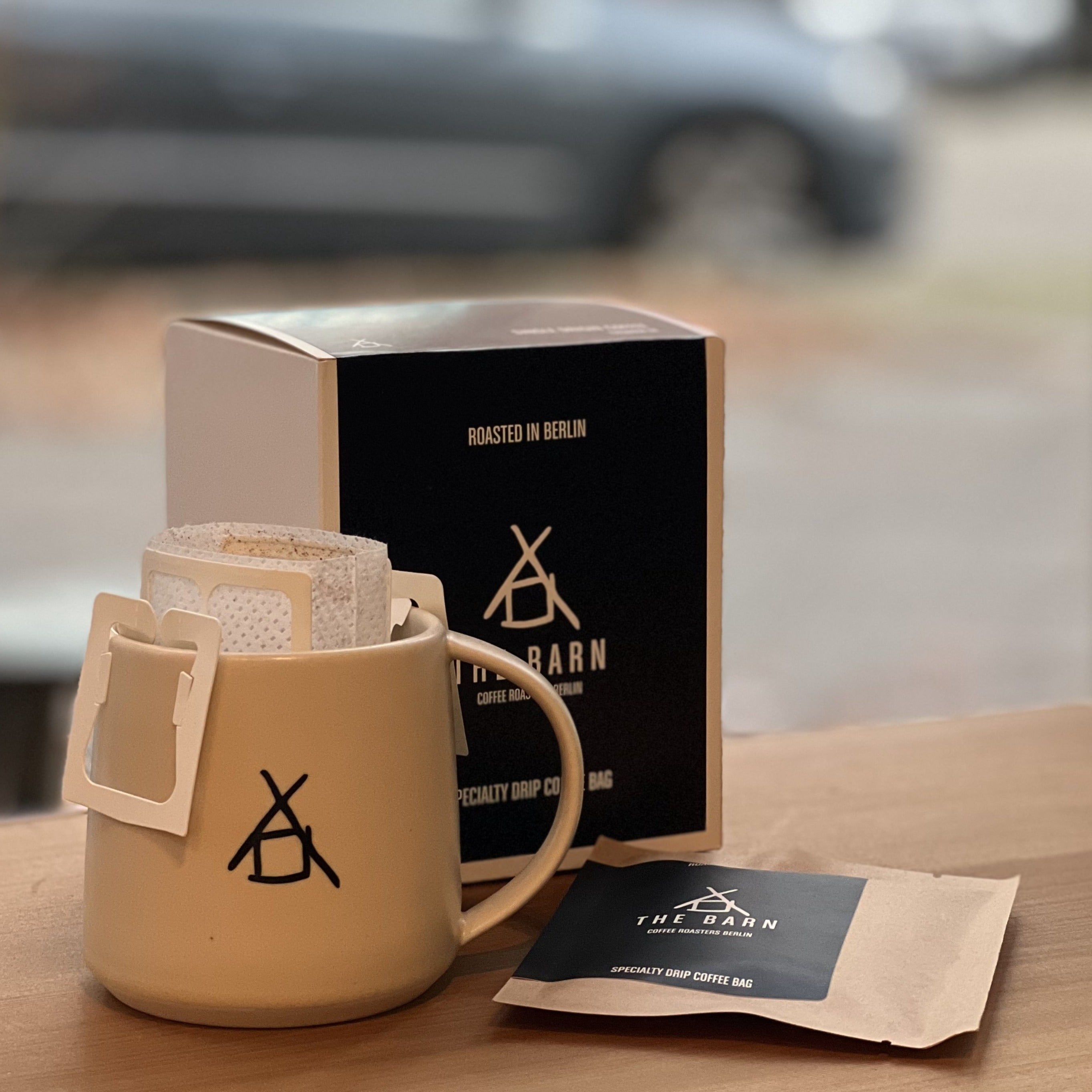 Coffee mug with coffee bags and instant drip coffee packaging on a table