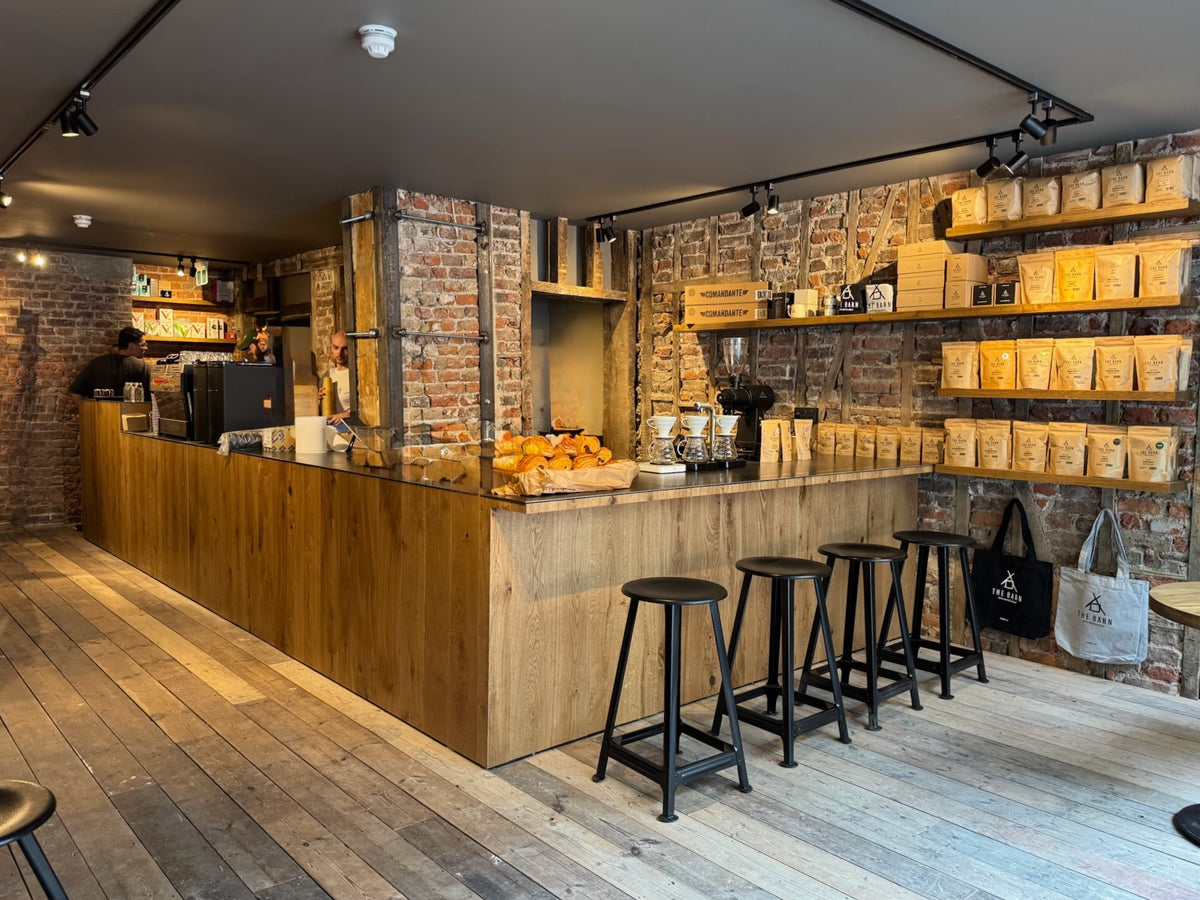 Interior view of THE BARN London with, with restored wooden floorboards and exposed brick.