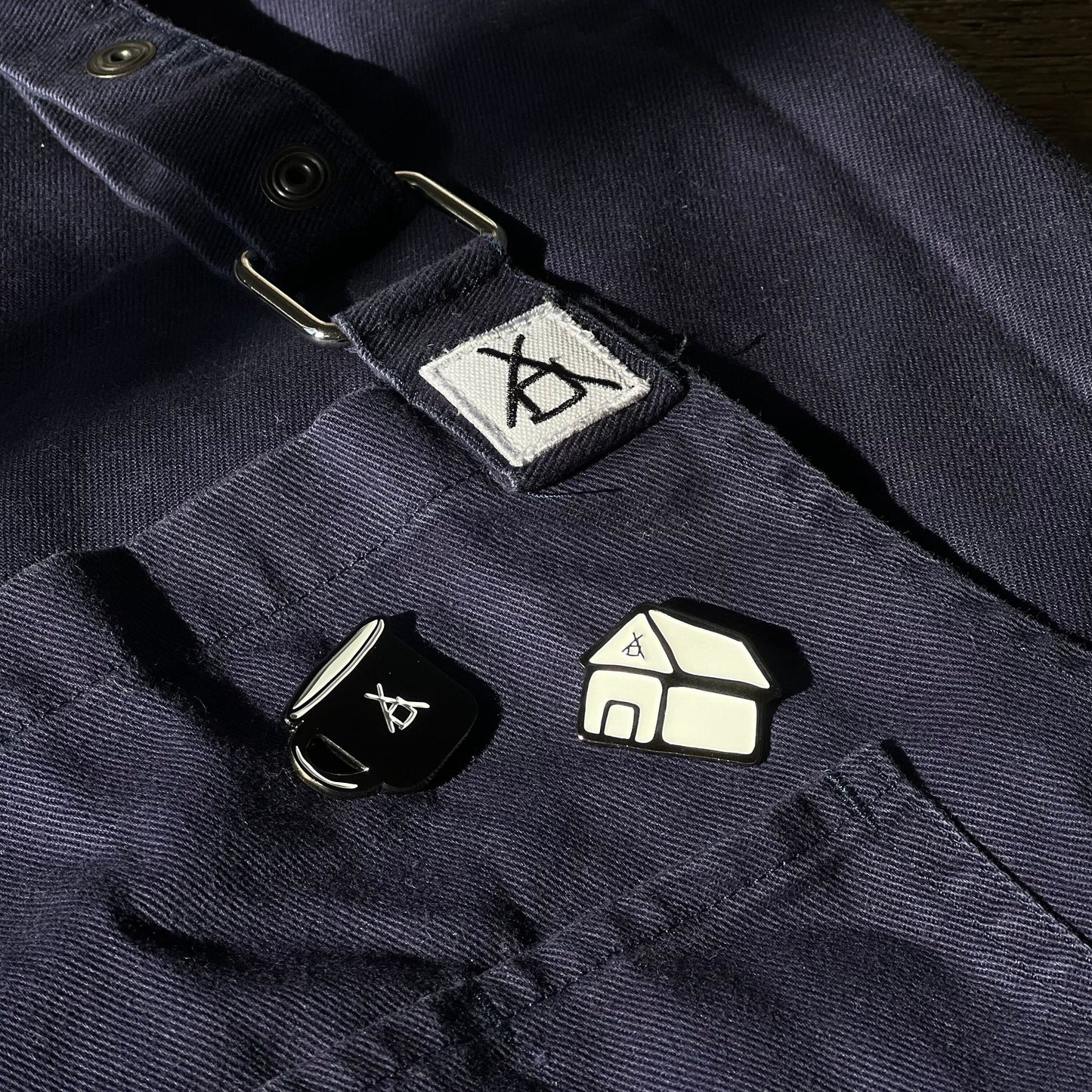 Enamel Pins on blue apron