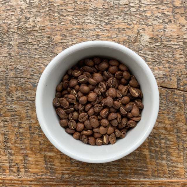 Roasted full coffee beans in a cup